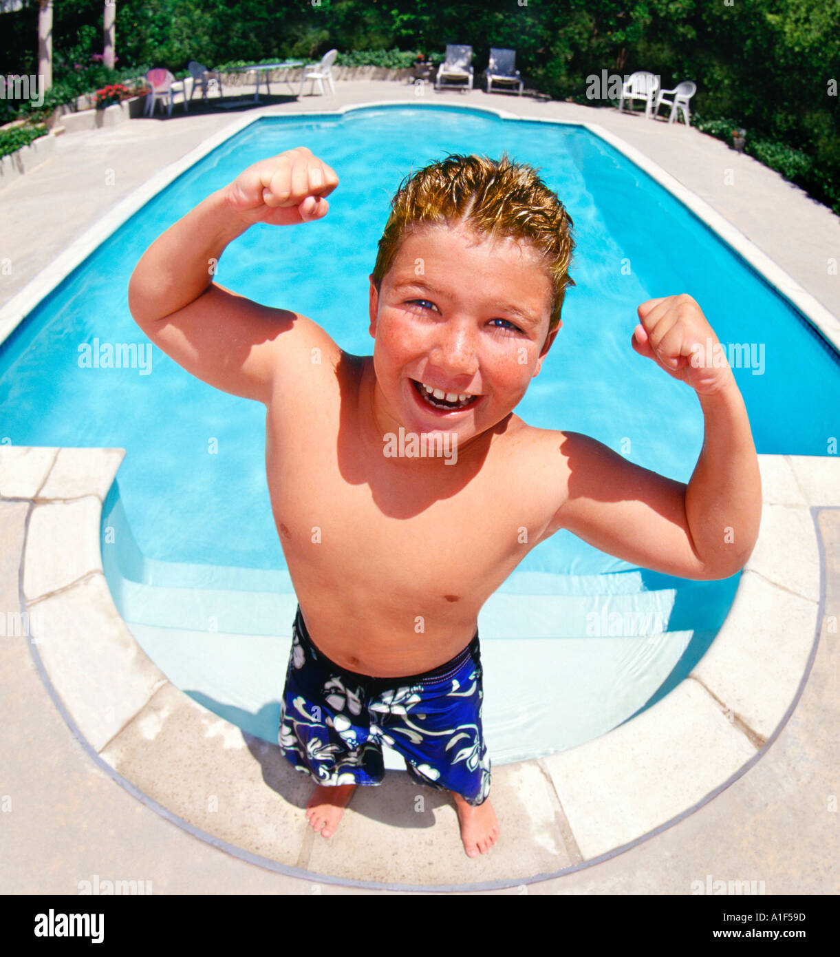 10 year old white boy making muscles by pool Stock Photo Alamy