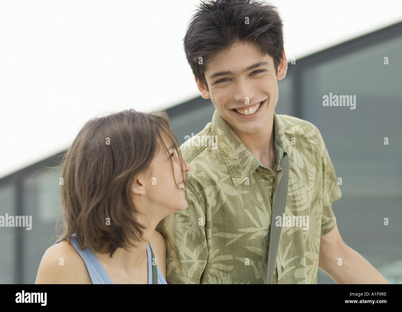 Young man and young woman laughing Stock Photo - Alamy