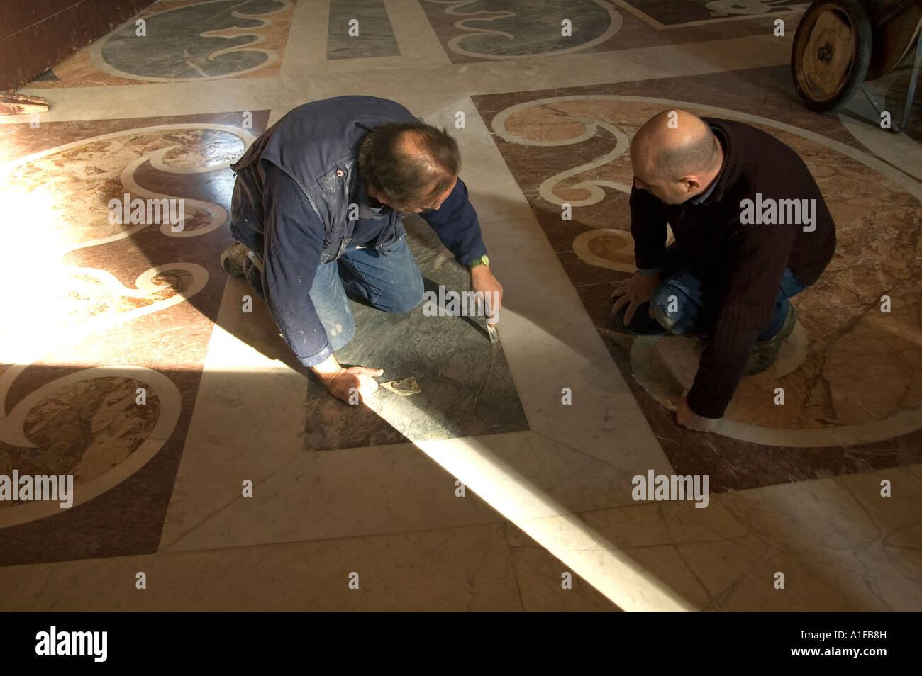 Restoration workers working on marble floor inside the Papal Basilica of Saint Peter or Saint Peter's Basilica located in the Vatican City Rome Italy Stock Photo