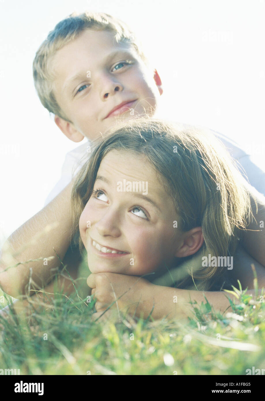Boy and girl lying in grass Stock Photo