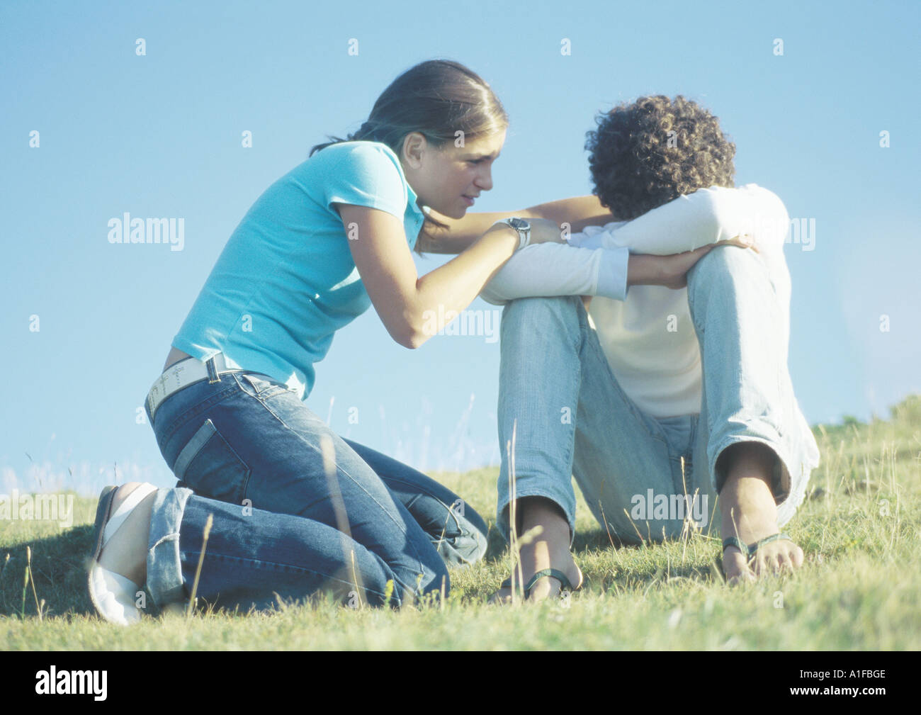 Teenage couple, girl trying to talk to boy with head down Stock Photo