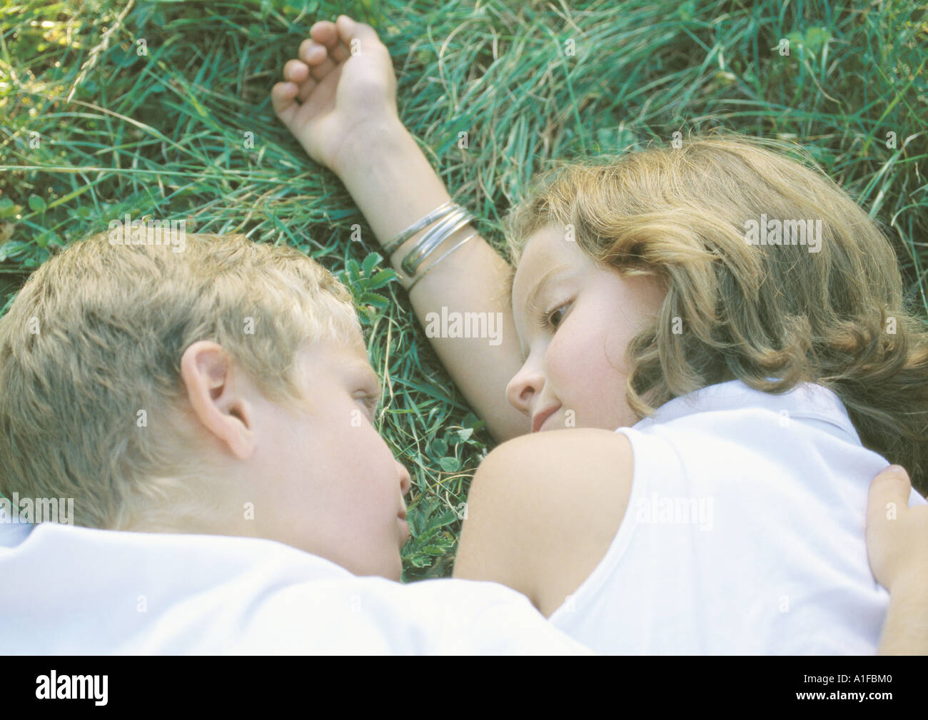 Boy and girl lying in grass Stock Photo