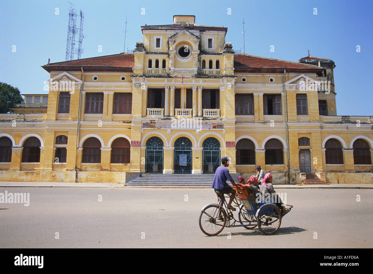 A cyclo passing the Old Post Office in Phnom Penh in Cambodia Asia T Hall Stock Photo