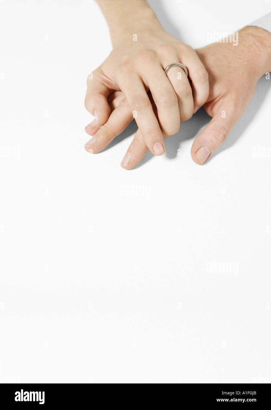 Woman wearing wedding ring clasping man’s hand Stock Photo - Alamy