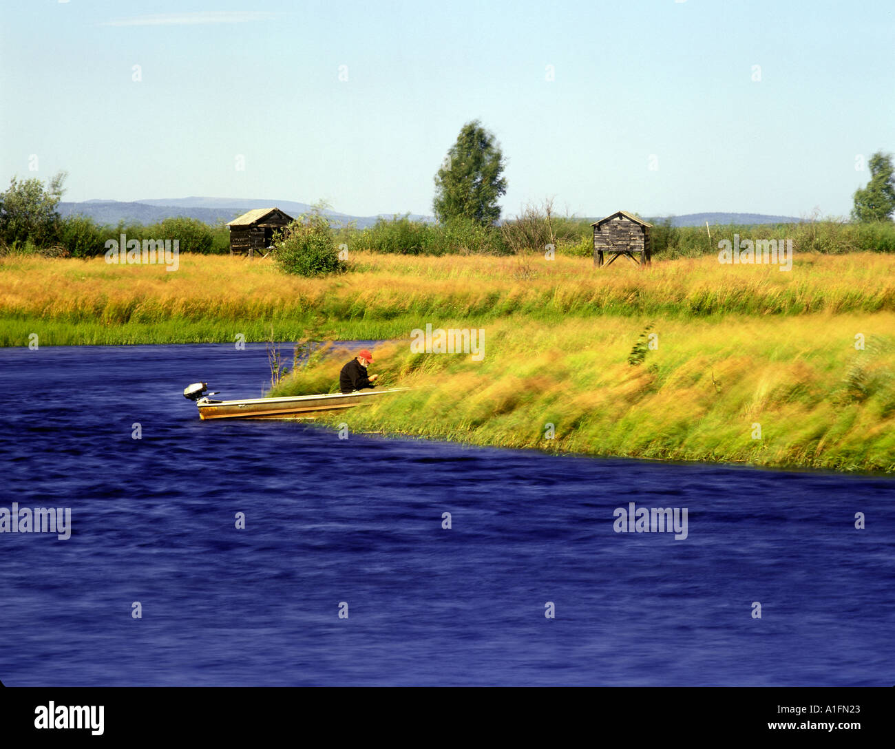 Fly fisherman preparing rig in boat at Minto Flats Alaska Stock Photo