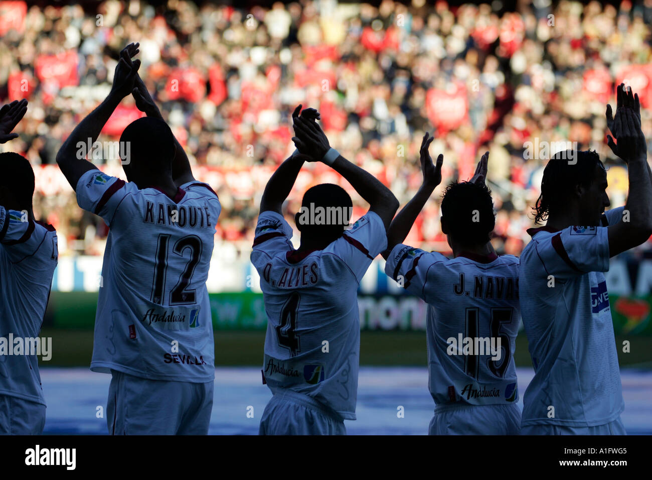 Outlined Sevilla FC players greeting and applauding their fans before a match Stock Photo