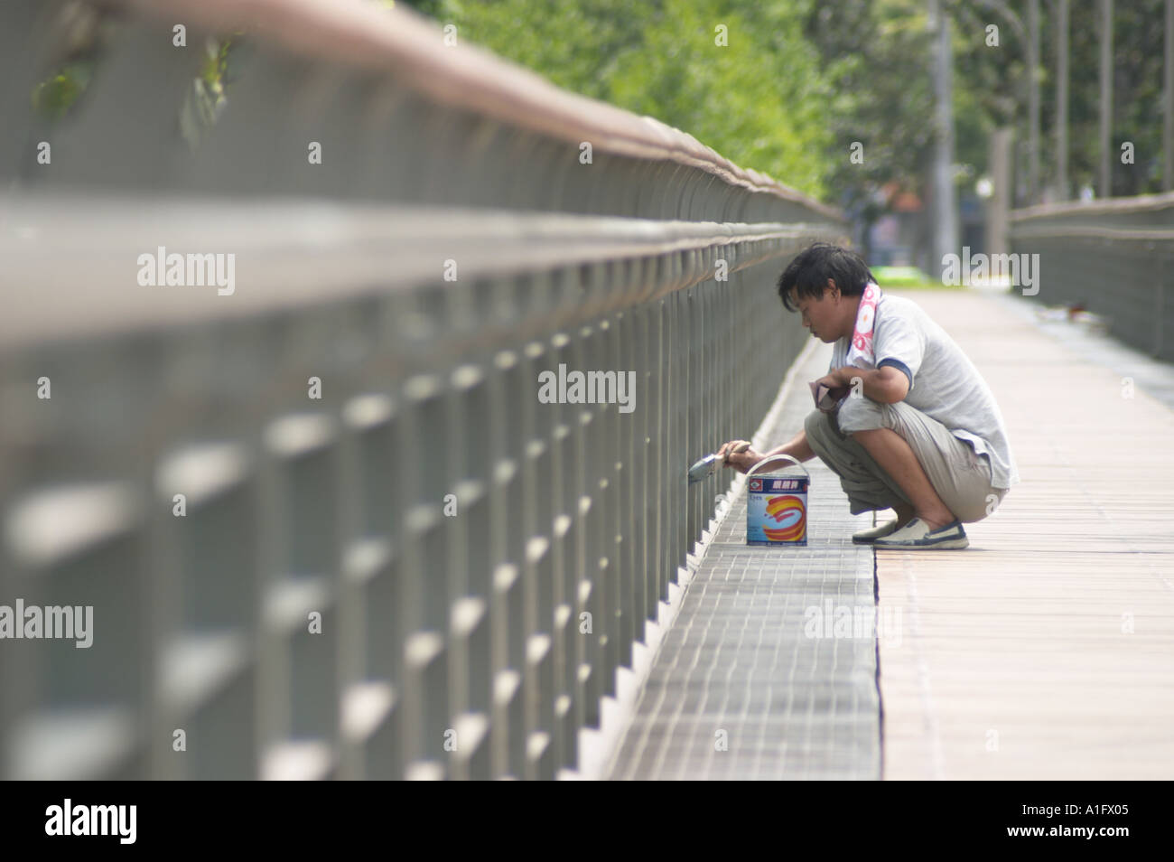 migrant worker painting bridge in xujiahui park shanghai china asia  Stock Photo