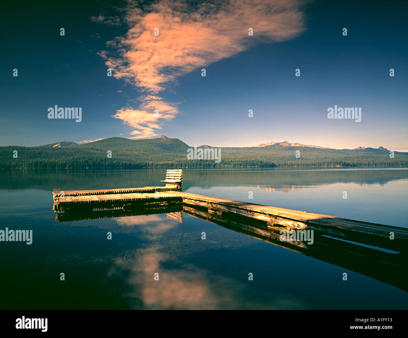Dock with bench and reflection in Odell Lake Oregon Stock Photo