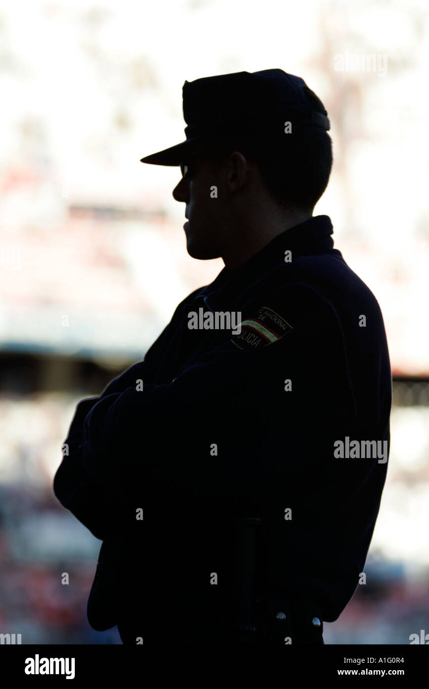 Silhouette of a policeman watching a football game, Seville, Spain Stock Photo
