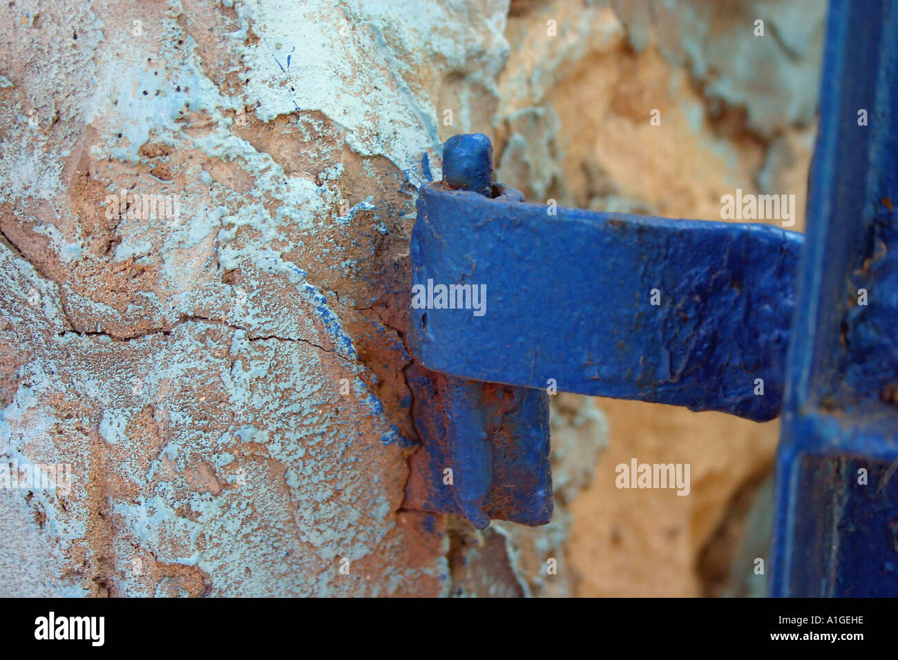 blue metal hinge connected to a stone wall Stock Photo - Alamy