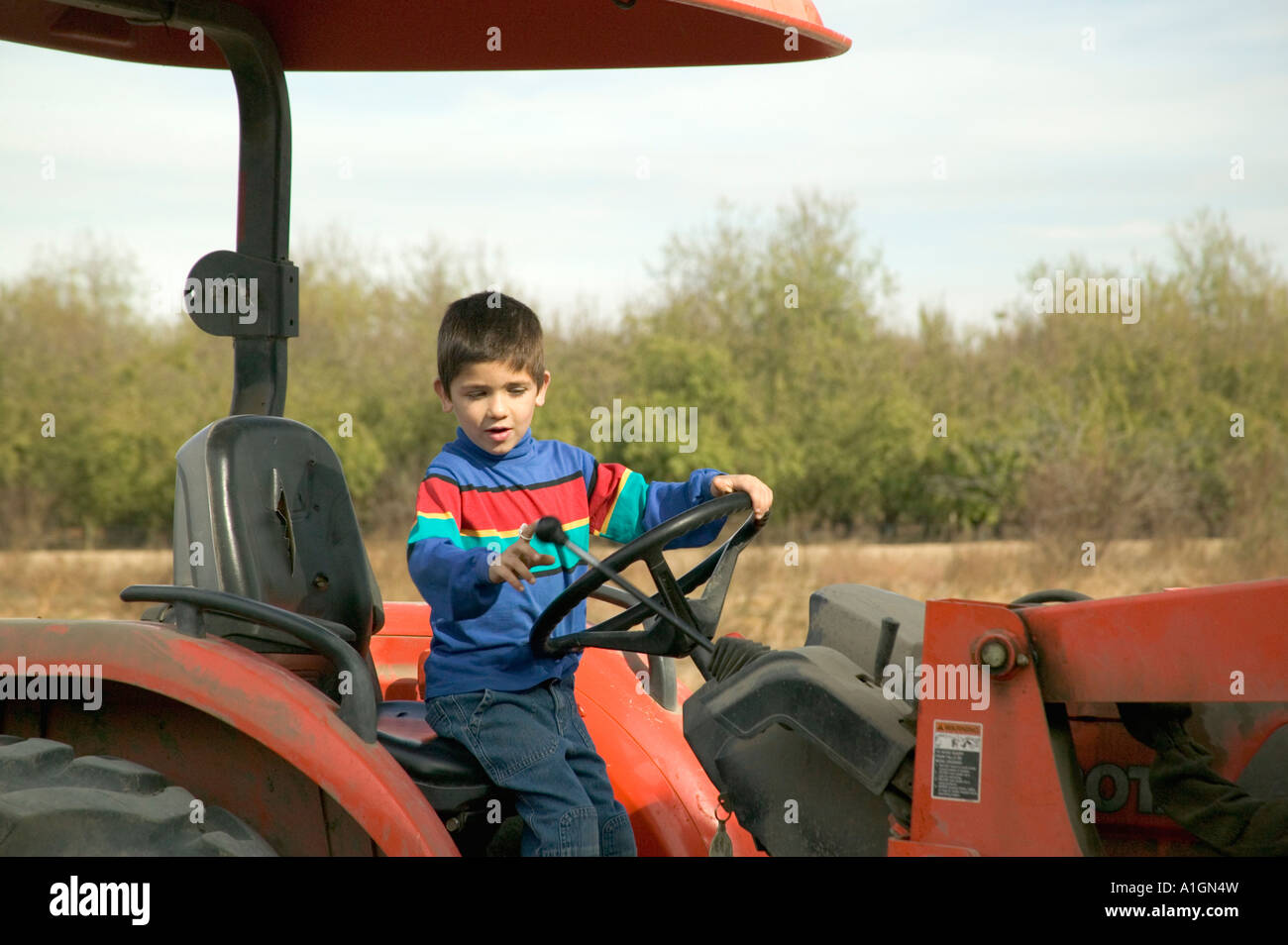 Six year old boy driving farm tractor, California Stock Photo Alamy