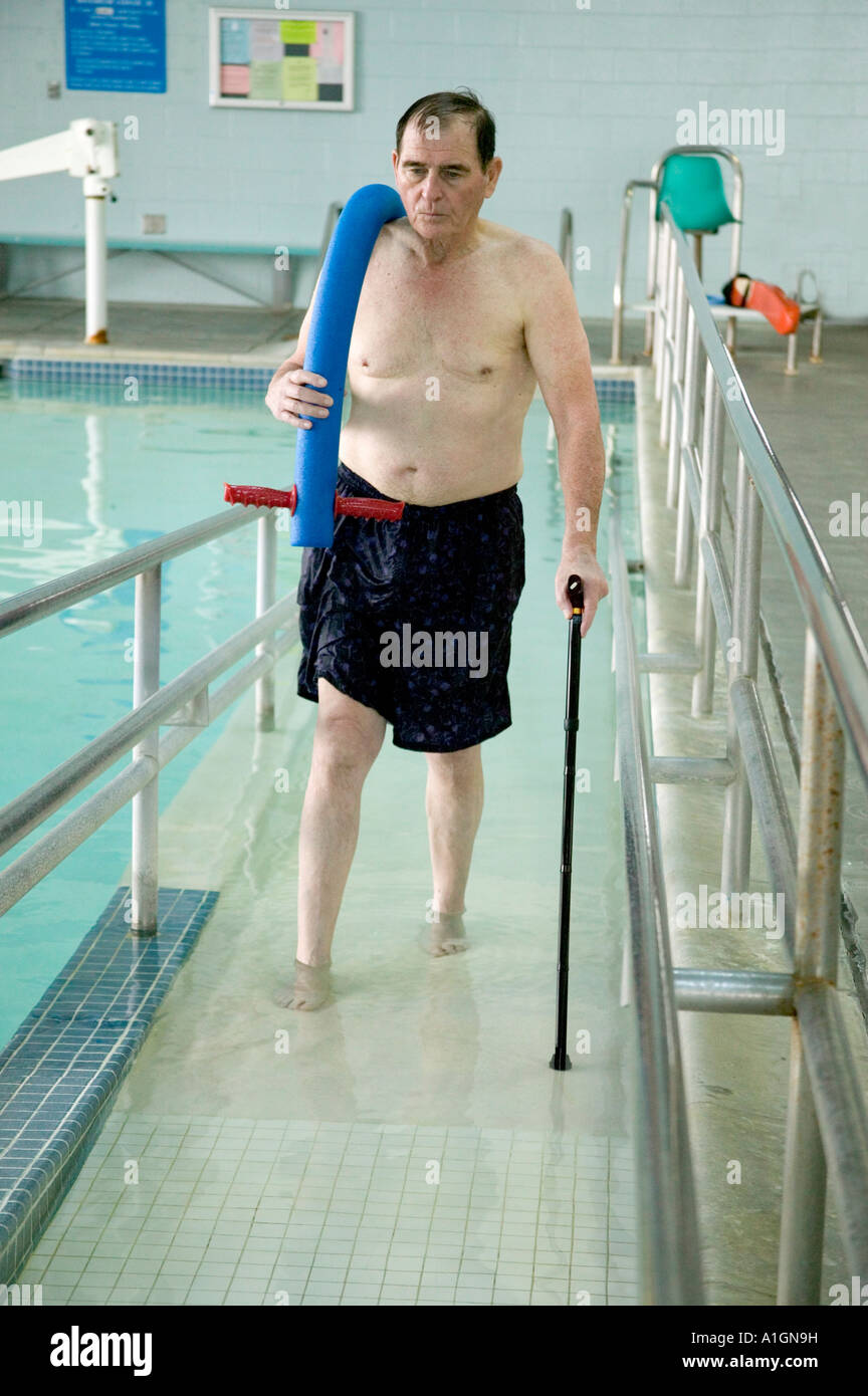 Senior male patient leaving therapy pool, recuperating from hip surgery Stock Photo