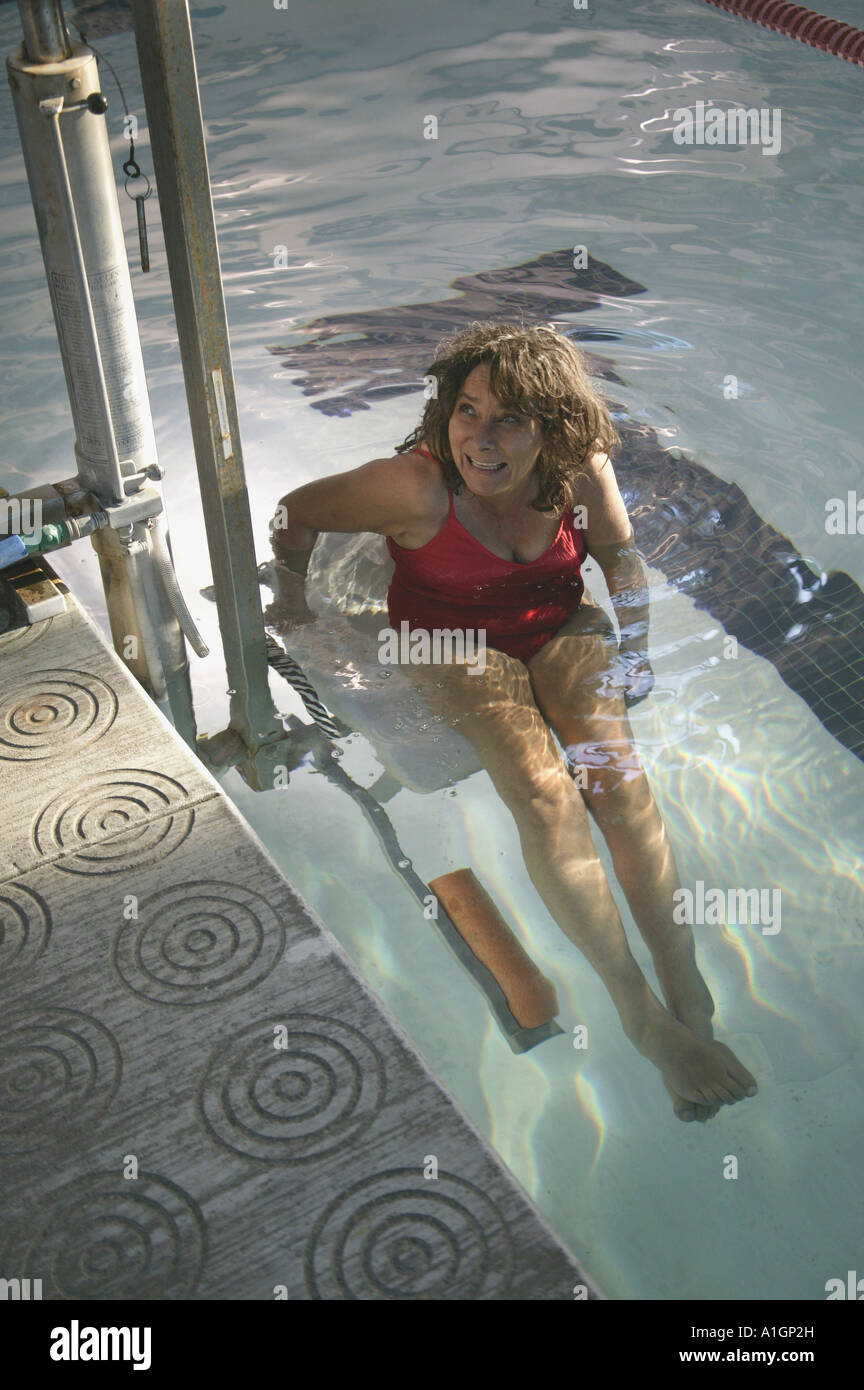 Handicapped woman entering swimming pool, Stock Photo