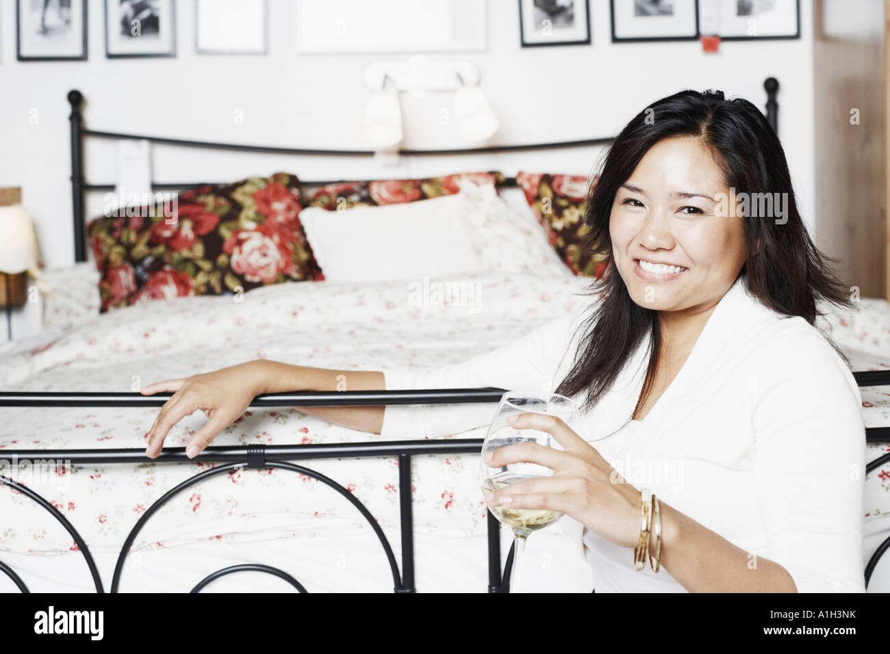 Portrait of a young woman holding a glass of wine smiling Stock Photo ...