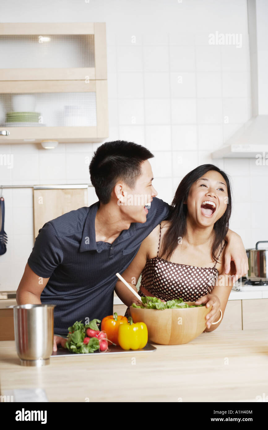 Young man embracing a young woman in the kitchen Stock Photo - Alamy