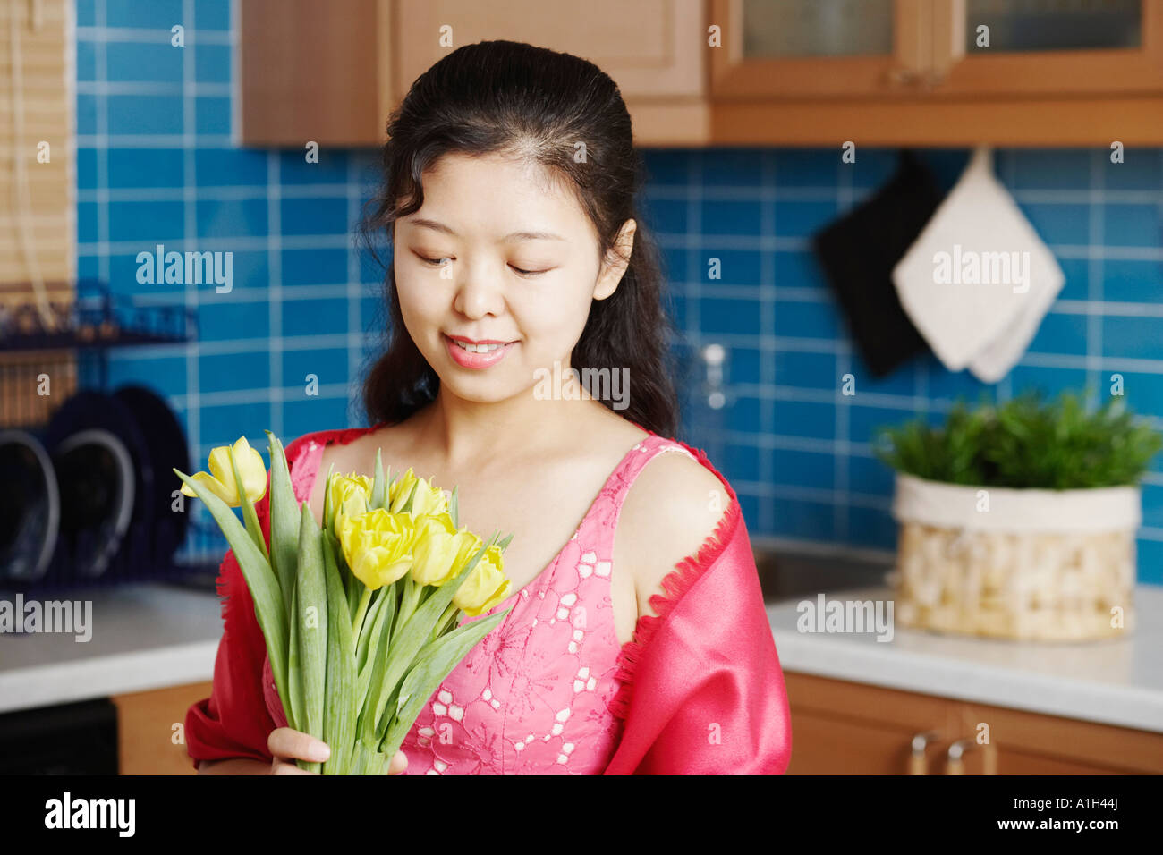 Close-up of a young woman holding a bunch of flowers smiling Stock ...
