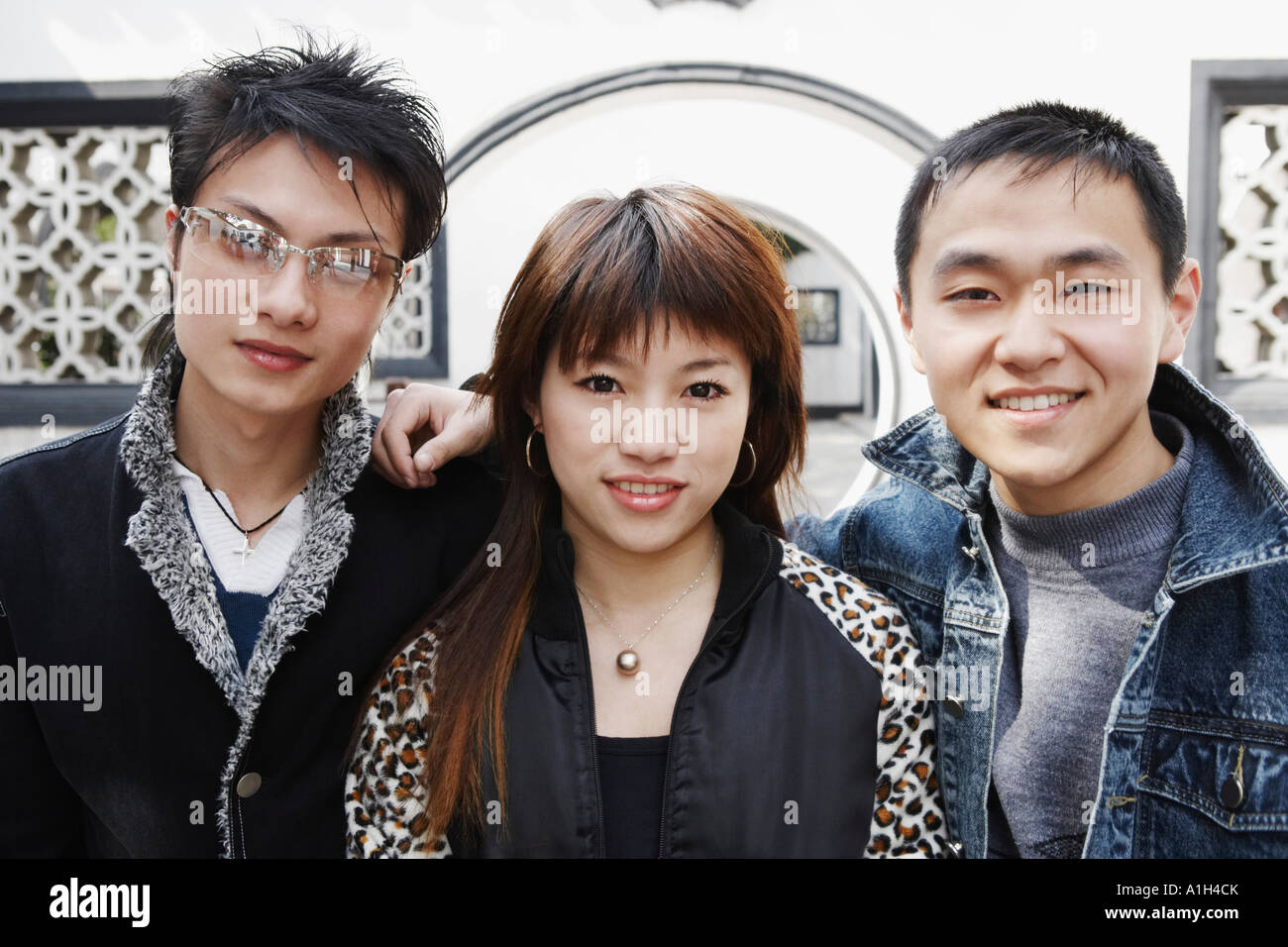 Portrait of a young woman posing with two young men Stock Photo - Alamy