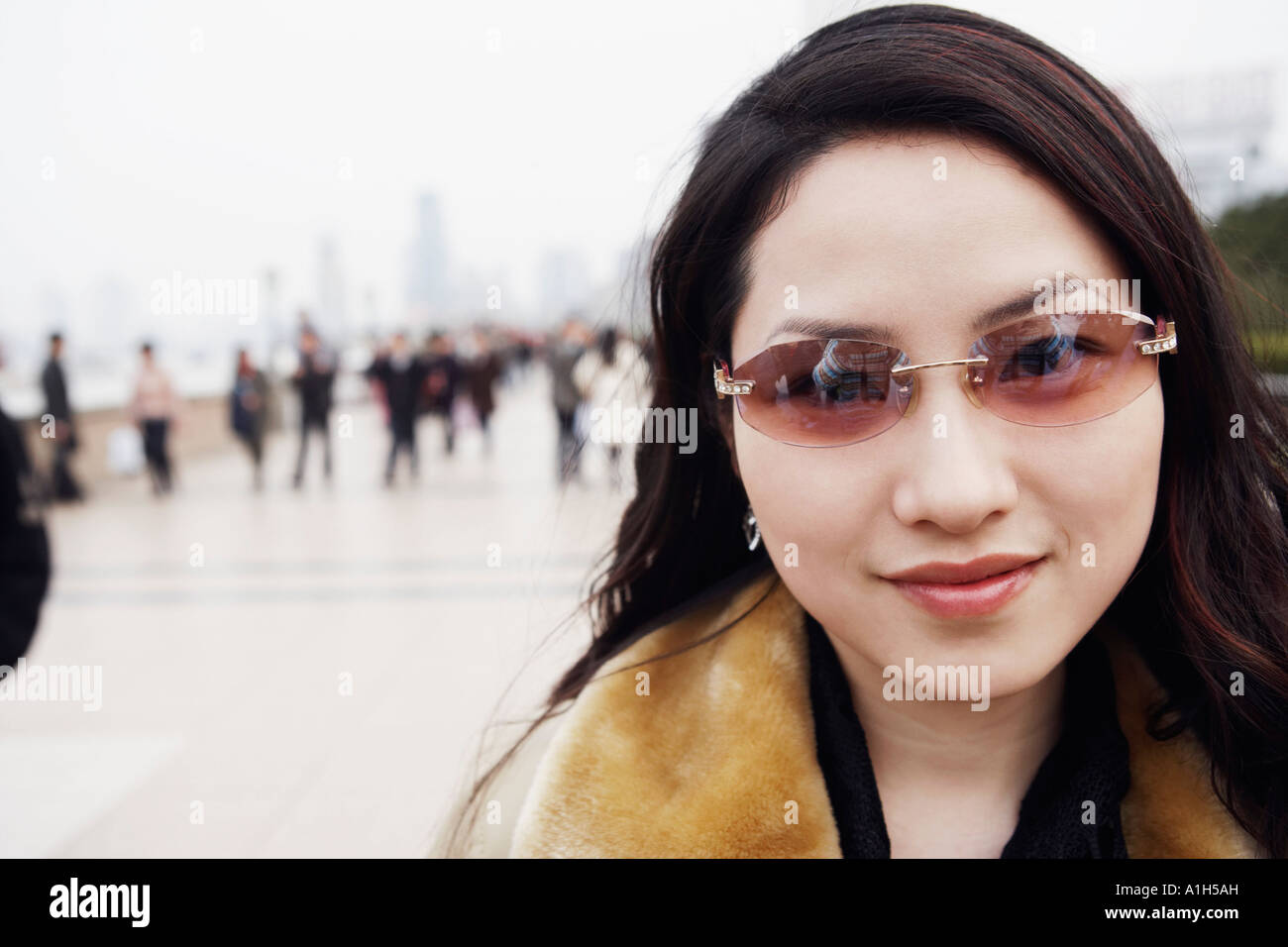 Portrait of a young woman wearing sunglasses smiling Stock Photo - Alamy