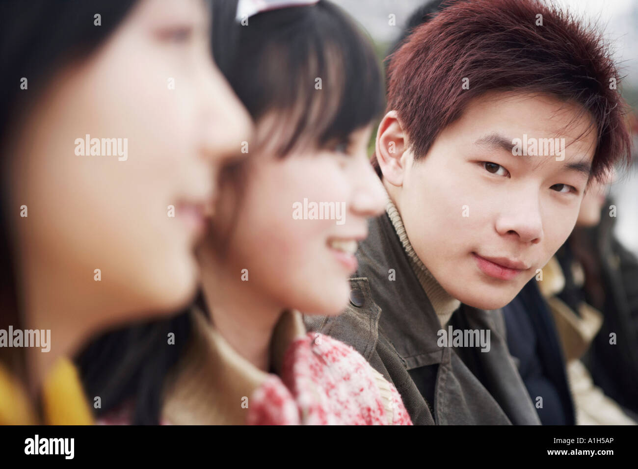 Close-up of a young man with two young women Stock Photo - Alamy