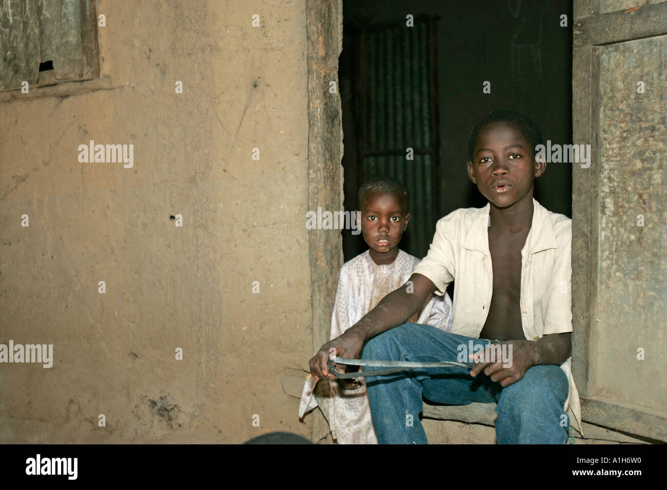 Boy in doorway with catapult Berending village south of The Gambia Stock Photo