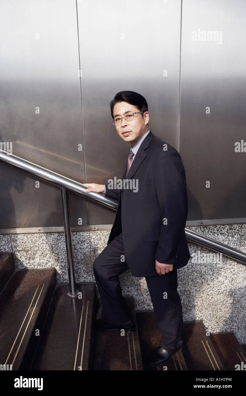 Portrait of a businessman walking up a staircase Stock Photo - Alamy