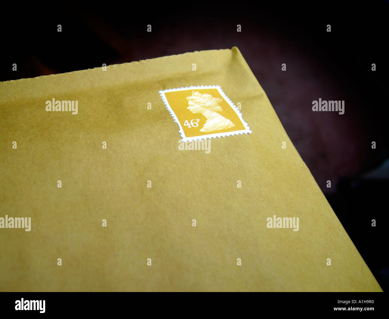 Postage stamp in corner of padded brown envelope Stock Photo Alamy