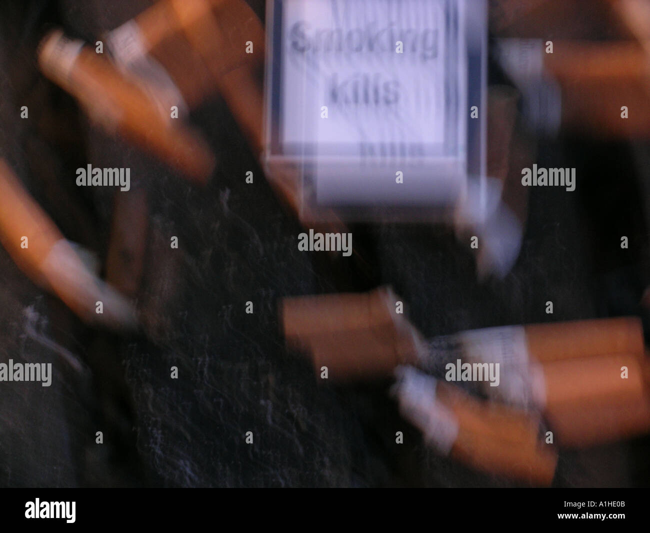 'smoking kills' - sign on packet of cigarettes & butts in ashtray, blurred Stock Photo