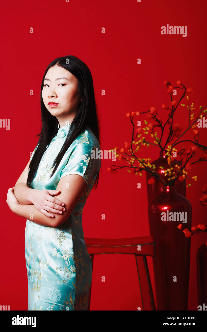 Portrait of a young woman standing near a flower pot Stock Photo - Alamy