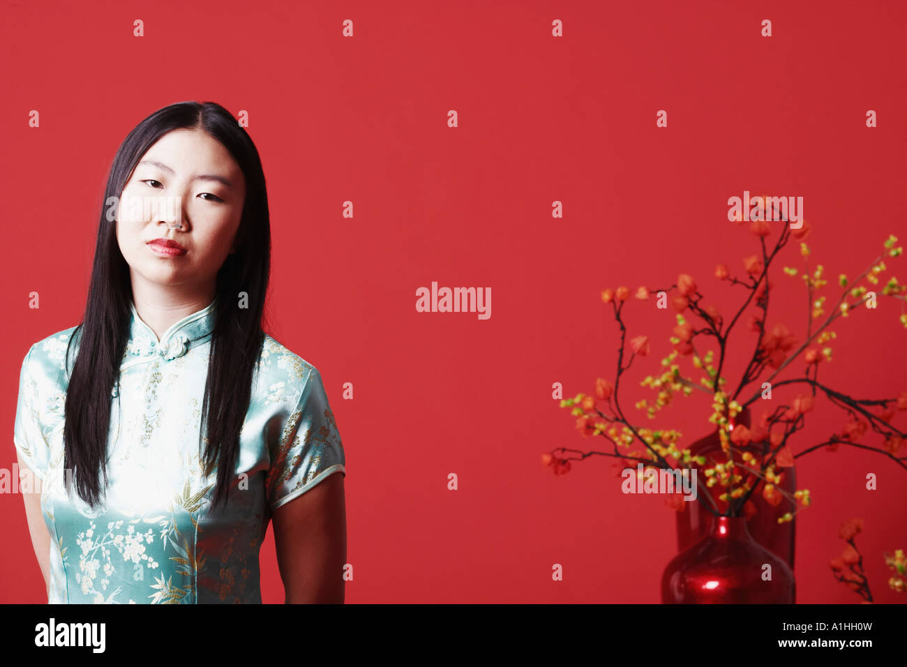 Portrait of a young woman standing near a flower pot Stock Photo - Alamy