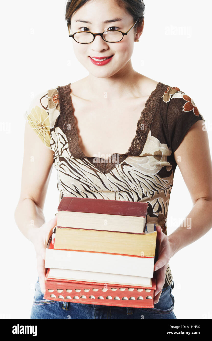 Portrait of a young woman holding books and smiling Stock Photo - Alamy