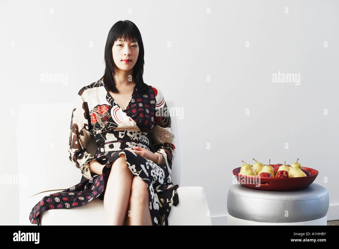 Portrait of a young woman sitting on a couch Stock Photo - Alamy