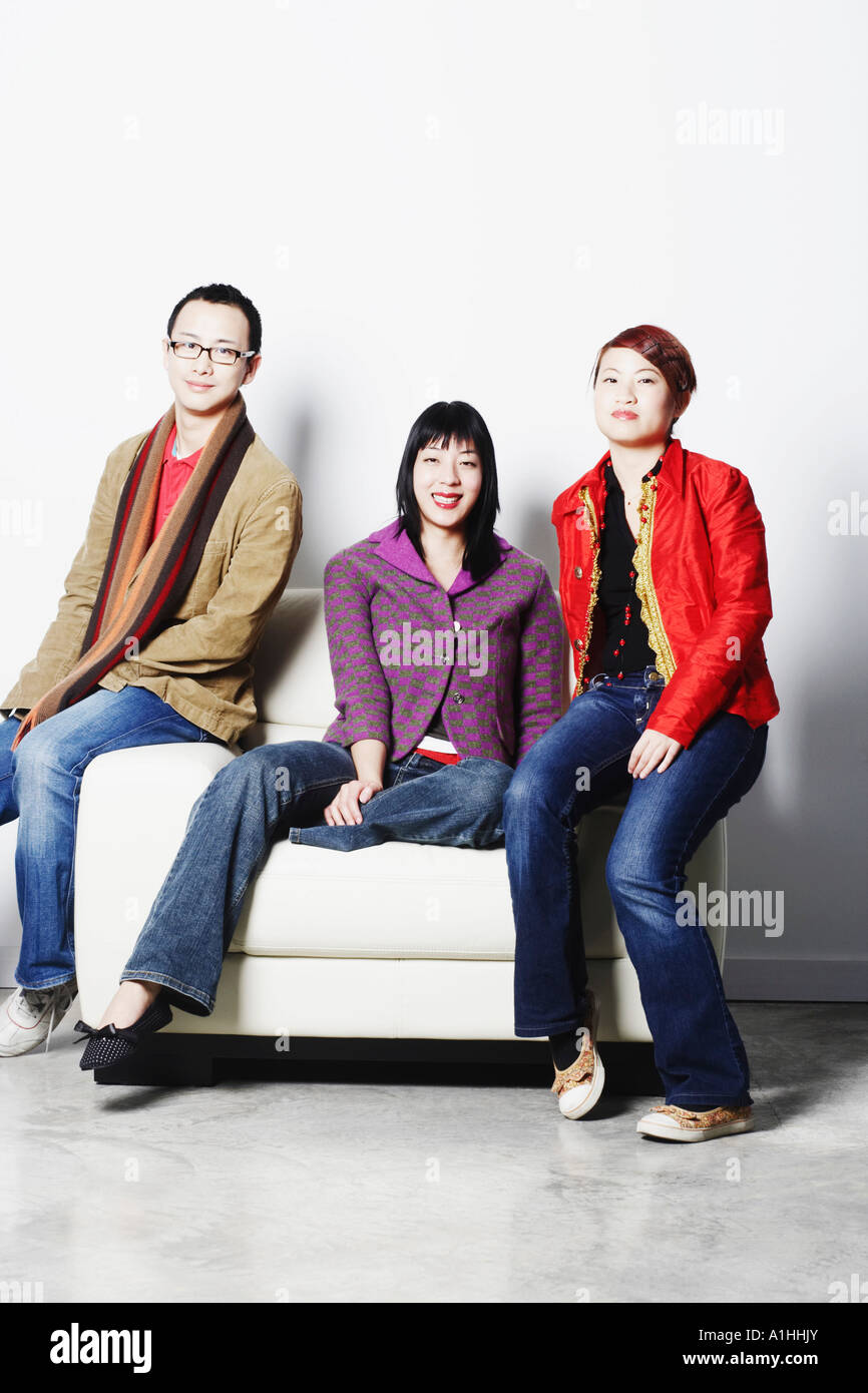 Portrait of a young man smiling with two young women Stock Photo - Alamy