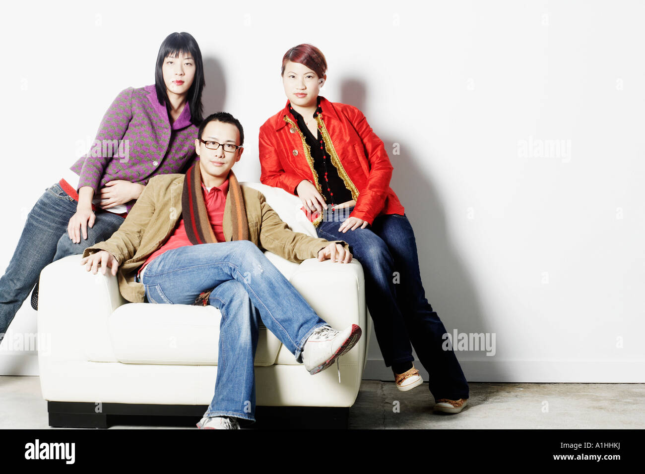 Portrait of a young man sitting with two young women Stock Photo - Alamy