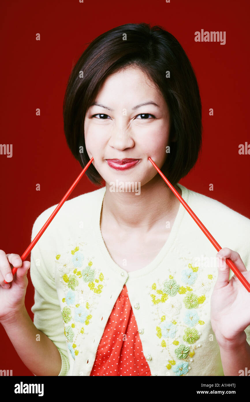 Portrait of a young woman holding chopsticks Stock Photo Alamy