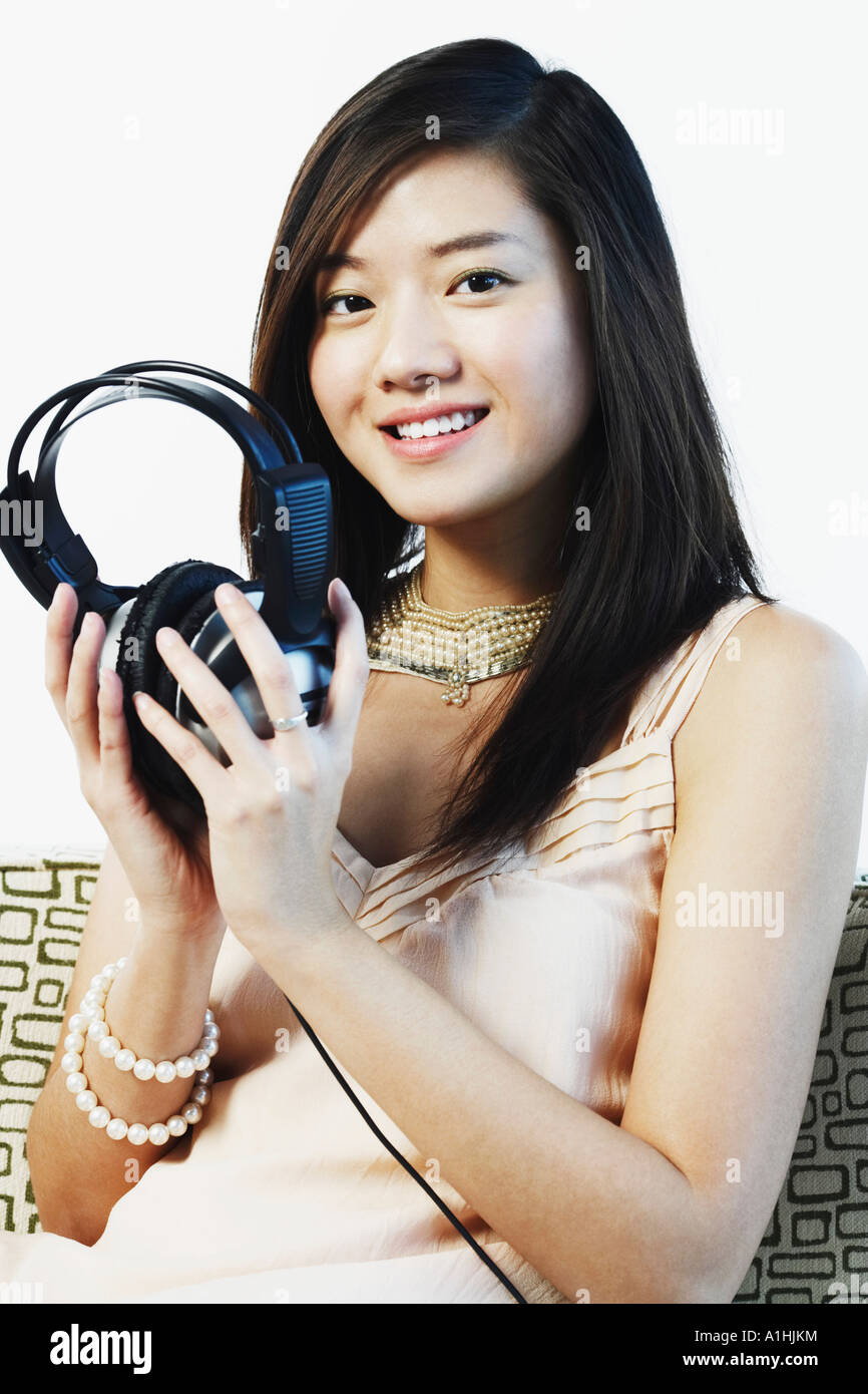 Portrait of a young woman holding headphones Stock Photo - Alamy