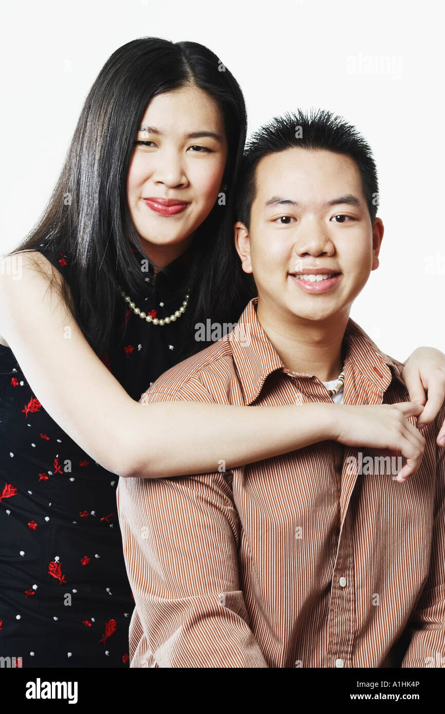 Portrait of a young woman embracing a young man from behind Stock Photo ...