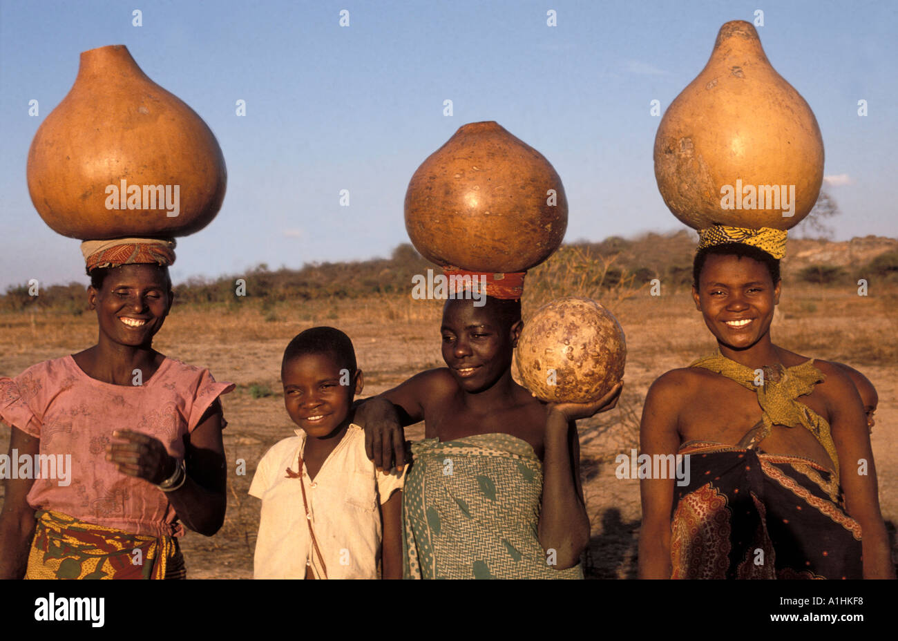 Women carrying water in big calebasses in Dodoma District Tanzania Stock Photo