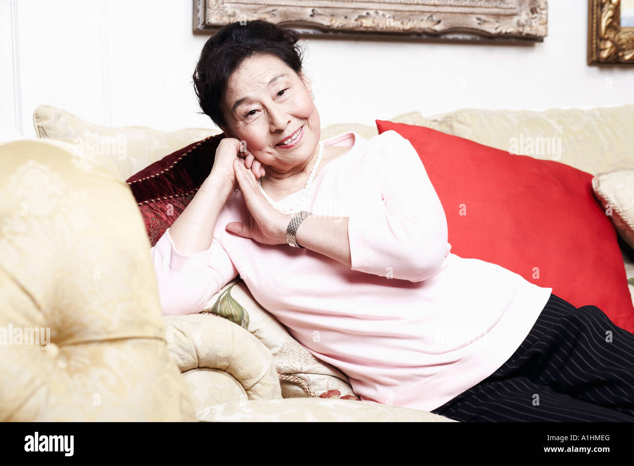 Portrait of a senior woman sitting on a couch Stock Photo - Alamy