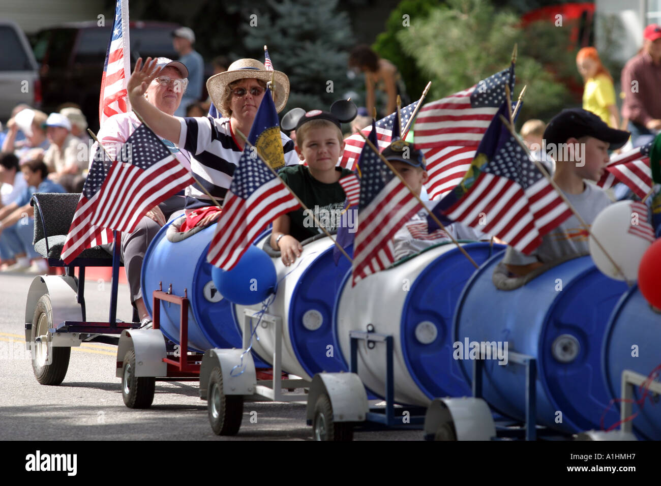 Peach day celebrations people waving US flags travelling in a miniature train Brigham City Utah