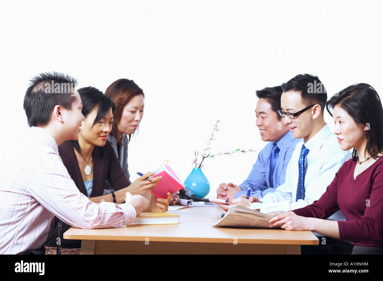 Three businessmen and three businesswomen sitting on chairs in a meeting Stock Photo