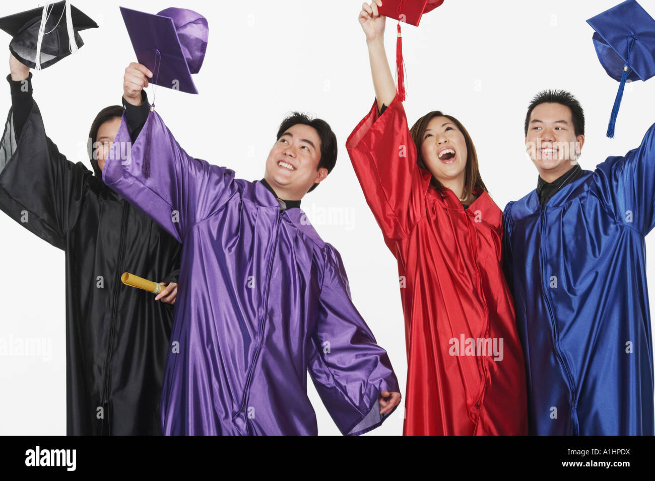 Two male graduates and two female graduates holding their mortar boards ...