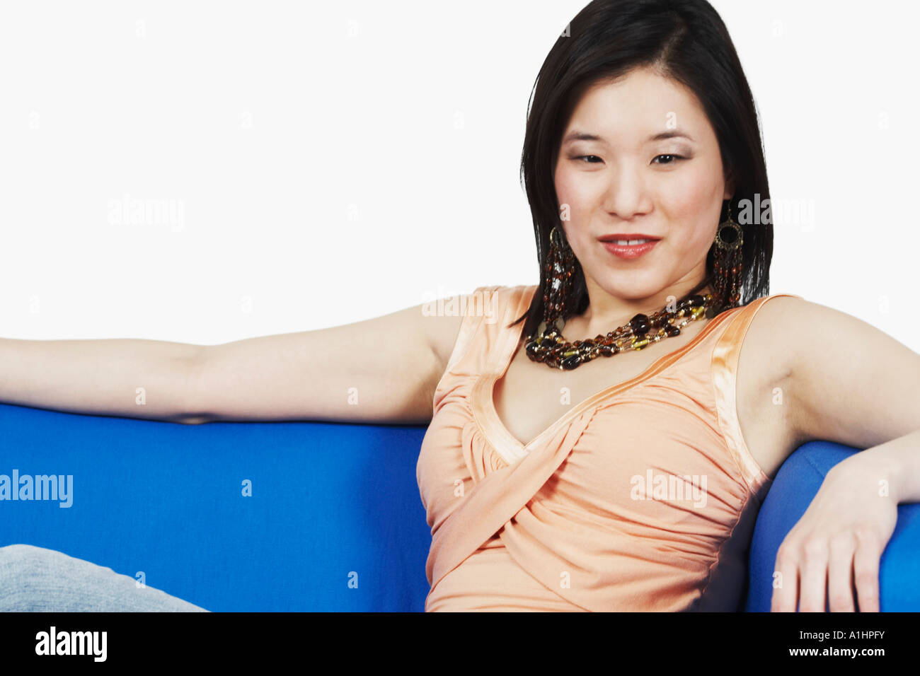 Close-up of a young woman sitting on a couch Stock Photo - Alamy