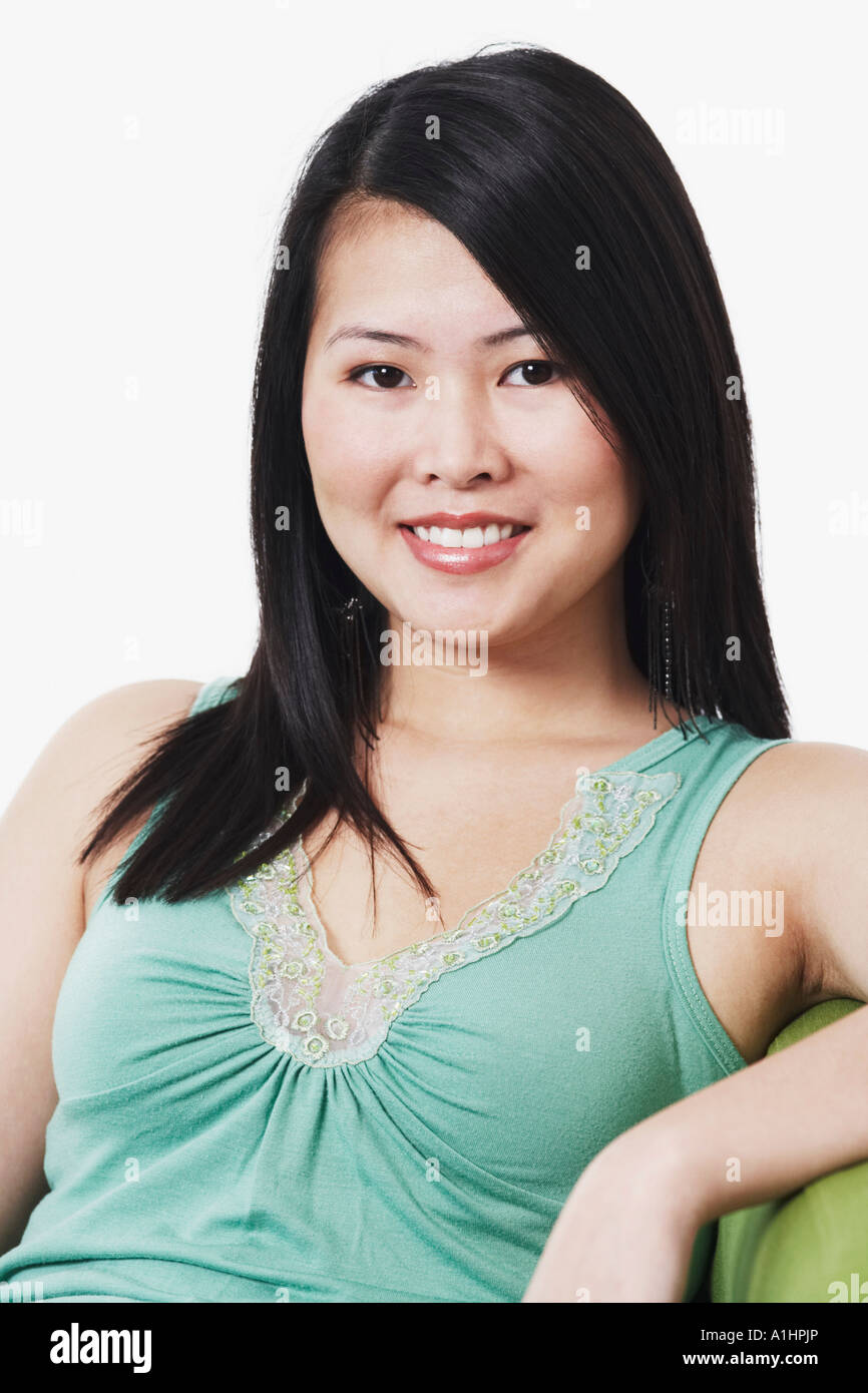Portrait of a young woman sitting on a couch smiling Stock Photo - Alamy
