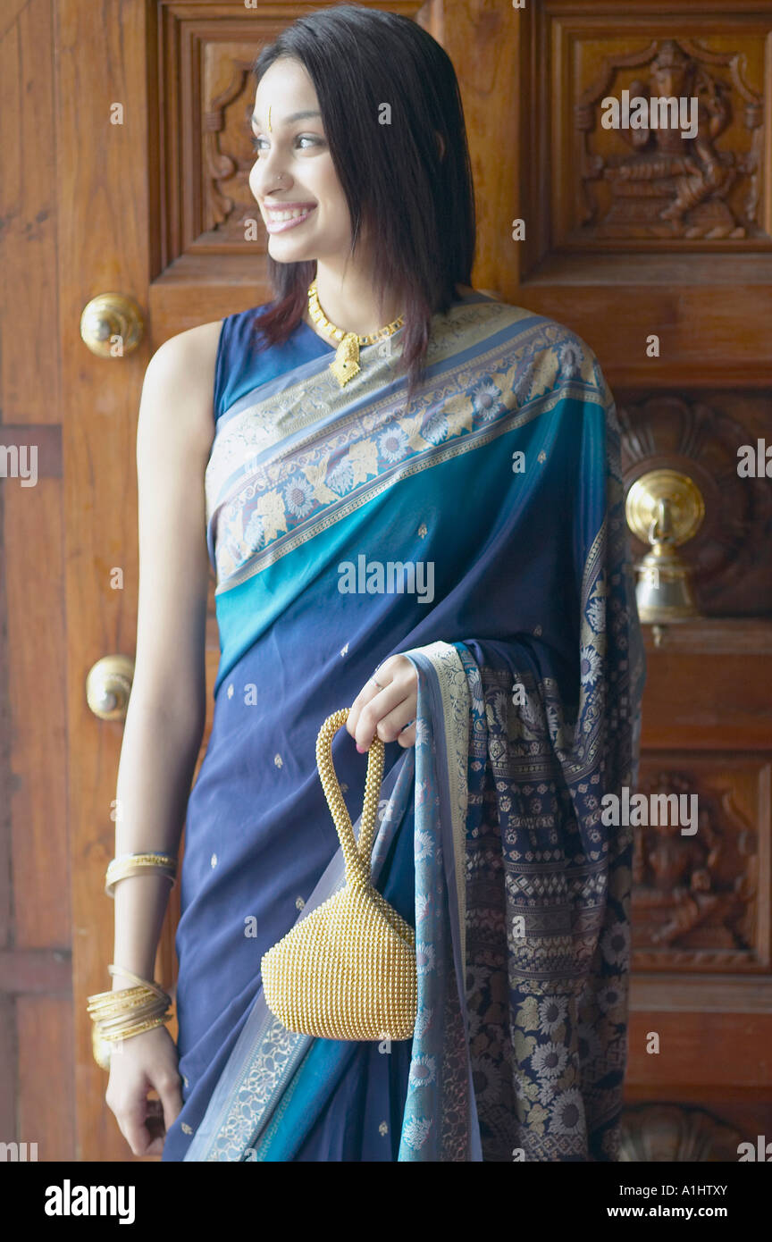 Young woman standing in front of a door Stock Photo - Alamy