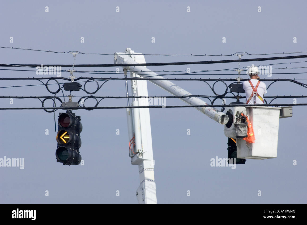 man working on street lights traffic signals bucket truck cherry picker occupations skills skilled trade electrical electrician Stock Photo