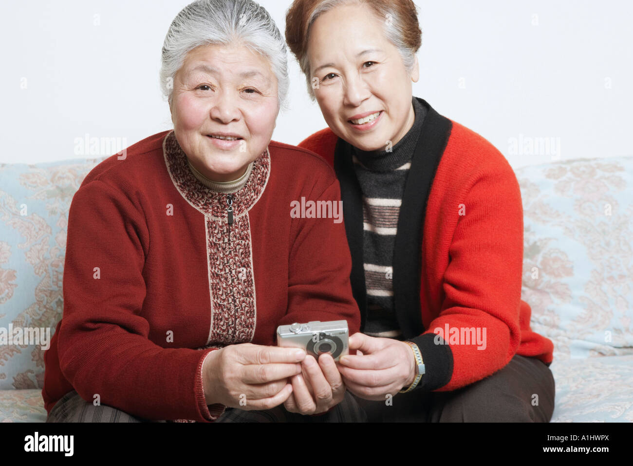 Portrait of a senior woman sitting on a couch with a mature woman ...