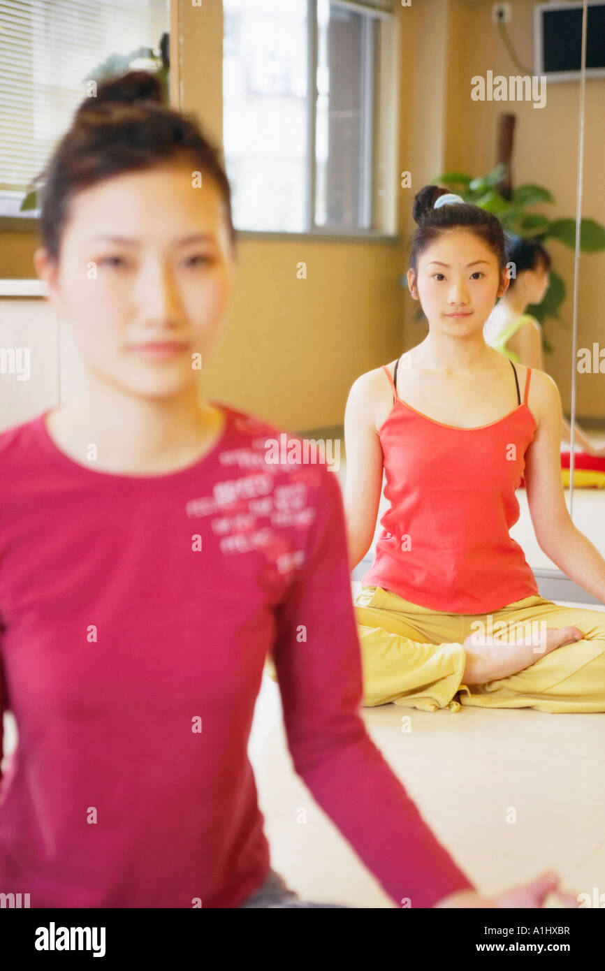 Three young women sitting in the lotus position Stock Photo