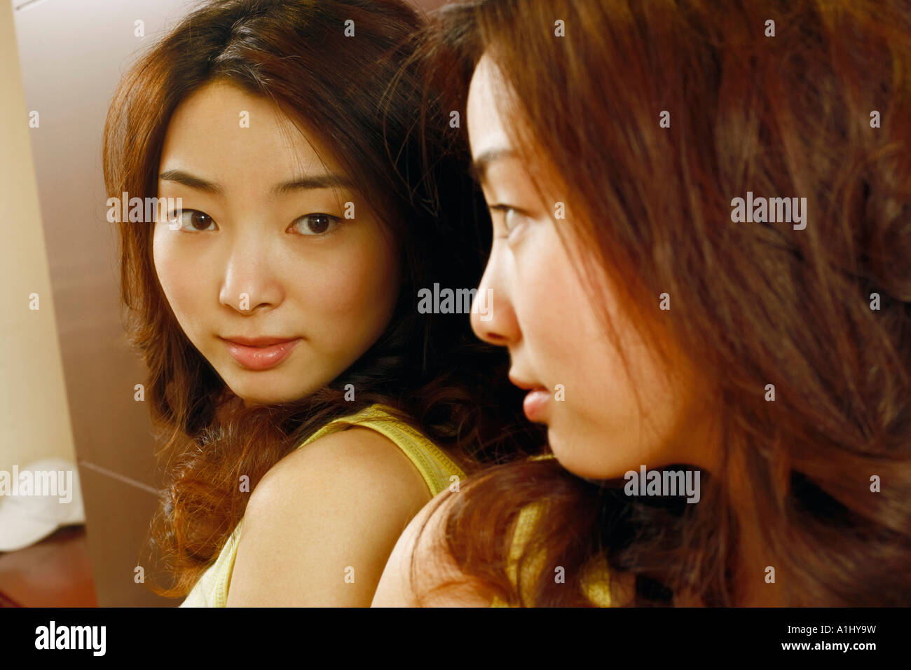 Close-up of a young woman looking in the mirror Stock Photo