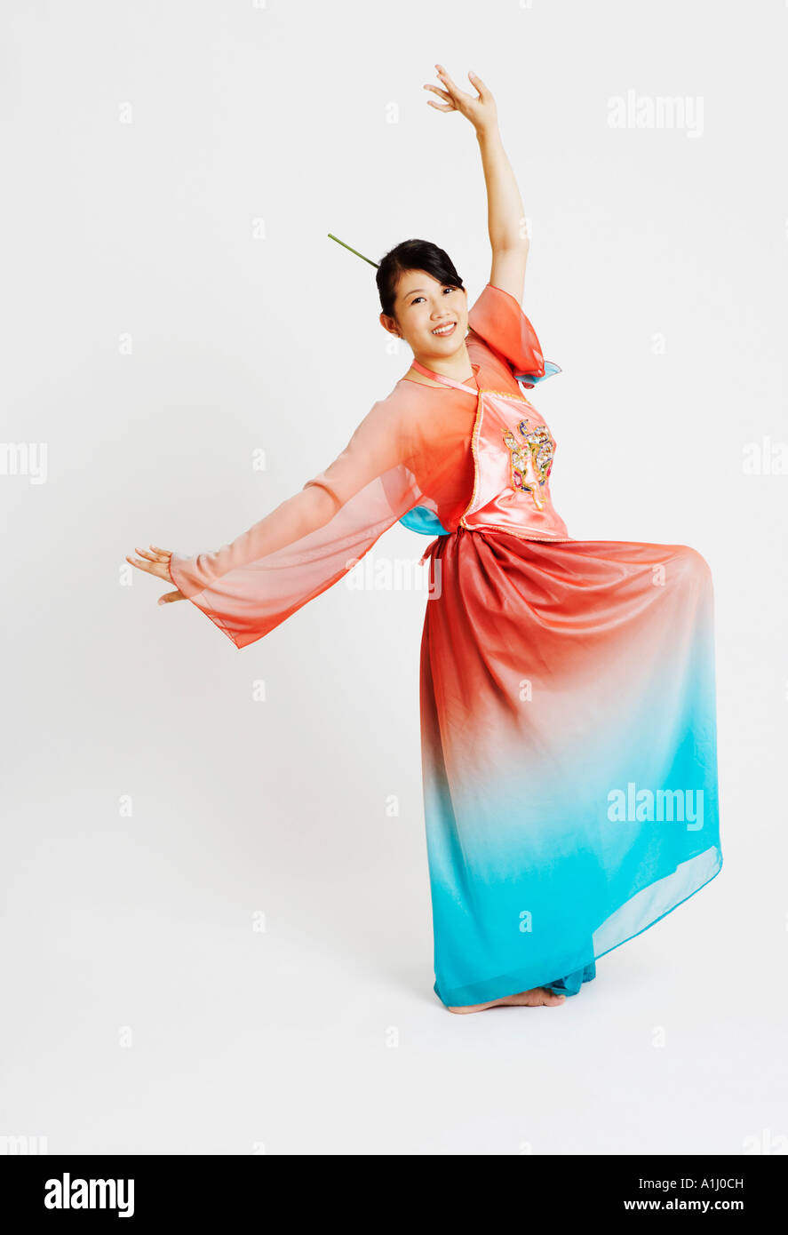 Portrait of a young woman wearing traditional clothing and dancing Stock Photo