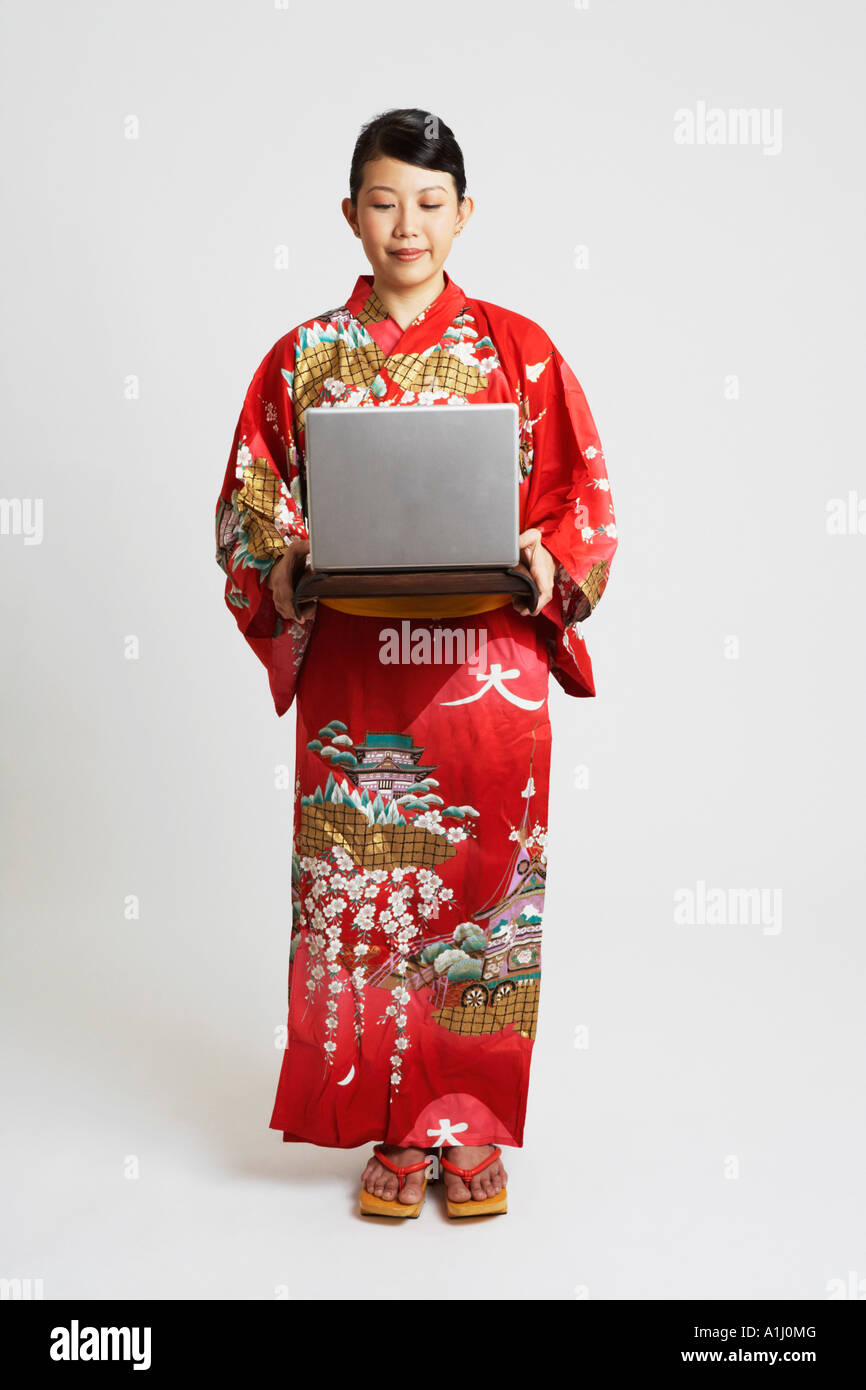 Close-up of a young woman holding a laptop on a tray Stock Photo